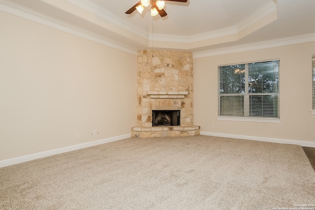 unfurnished living room featuring carpet, ceiling fan, a raised ceiling, and crown molding