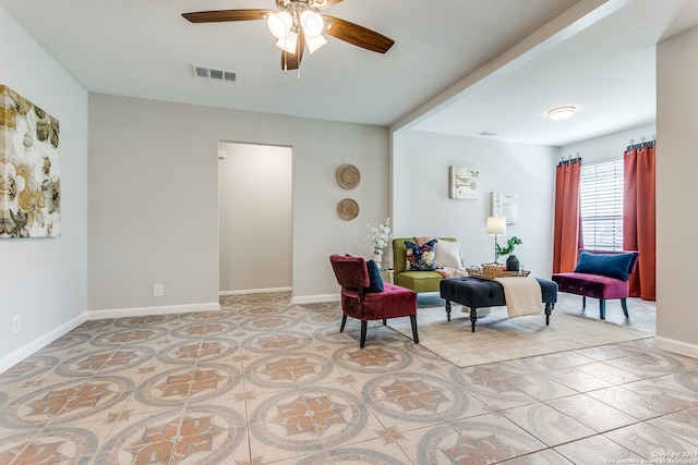 living area with ceiling fan and light tile patterned floors