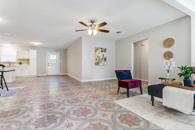 tiled living room with ceiling fan and sink