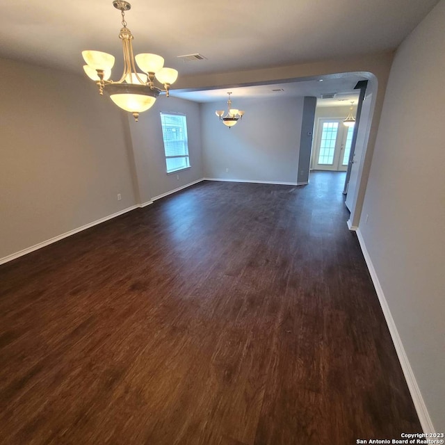 empty room featuring dark hardwood / wood-style floors and a chandelier