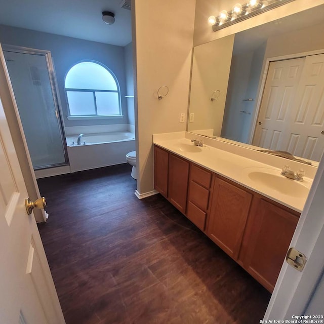 full bathroom featuring hardwood / wood-style floors, vanity, toilet, and separate shower and tub