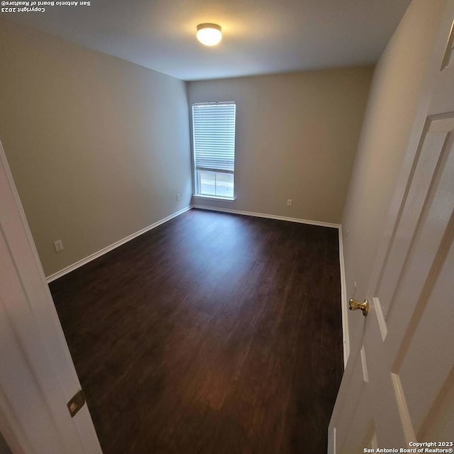 spare room with dark wood-type flooring