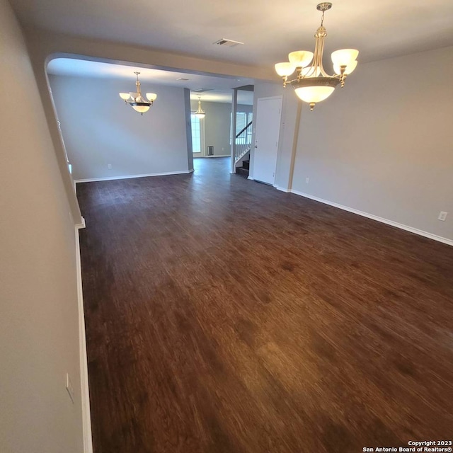 unfurnished room with dark hardwood / wood-style flooring and a chandelier