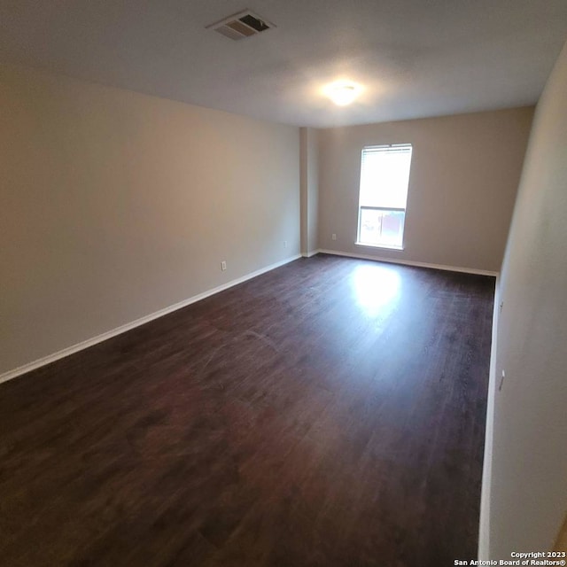 unfurnished room featuring dark hardwood / wood-style flooring