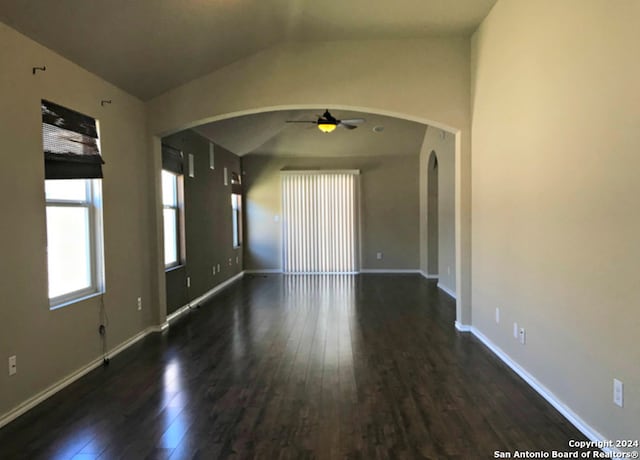 empty room with dark hardwood / wood-style floors, ceiling fan, and lofted ceiling