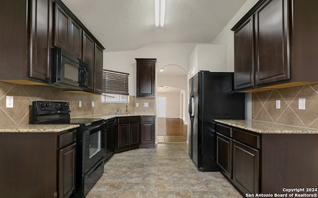 kitchen featuring dark brown cabinetry, light stone countertops, tasteful backsplash, a textured ceiling, and black appliances