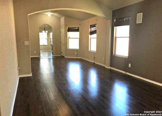 unfurnished room featuring dark hardwood / wood-style floors and lofted ceiling