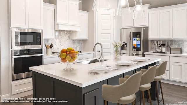 1849 Gyst Rd, Seguin, TX 78155 - kitchen featuring appliances with stainless steel finishes, a sink, white cabinetry, light countertops, and tasteful backsplash