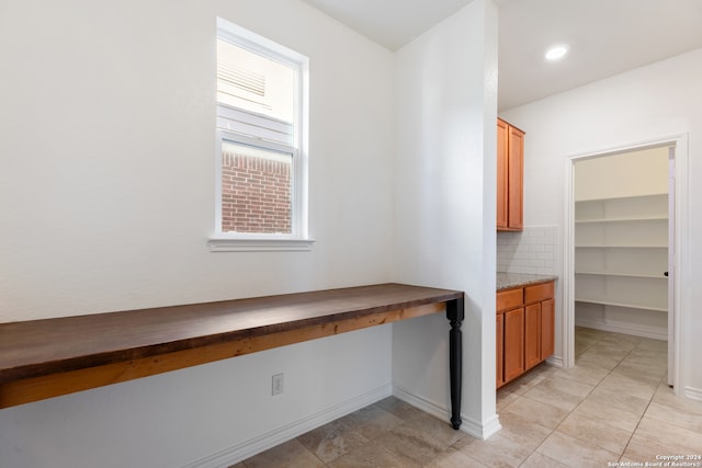 interior space with built in desk and light tile patterned floors