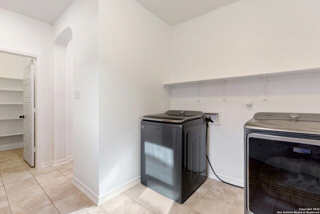 laundry room featuring washer and dryer and light tile patterned floors