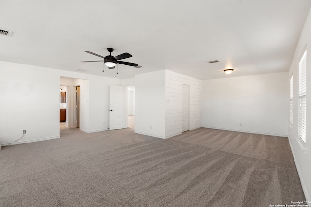 spare room with a wealth of natural light, light carpet, and ceiling fan