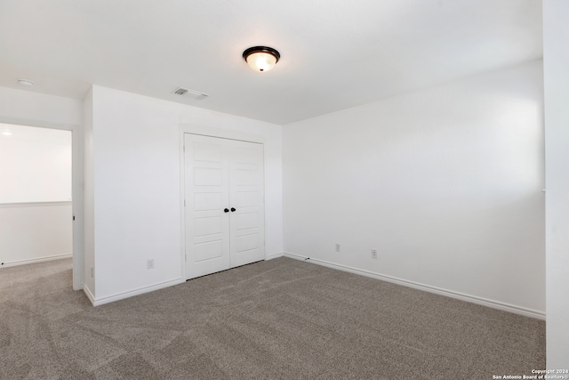 unfurnished bedroom featuring carpet flooring and a closet