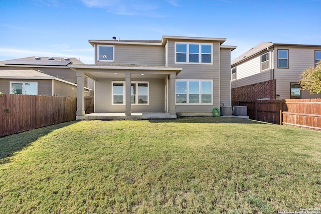 rear view of house with a yard, a patio, and central AC