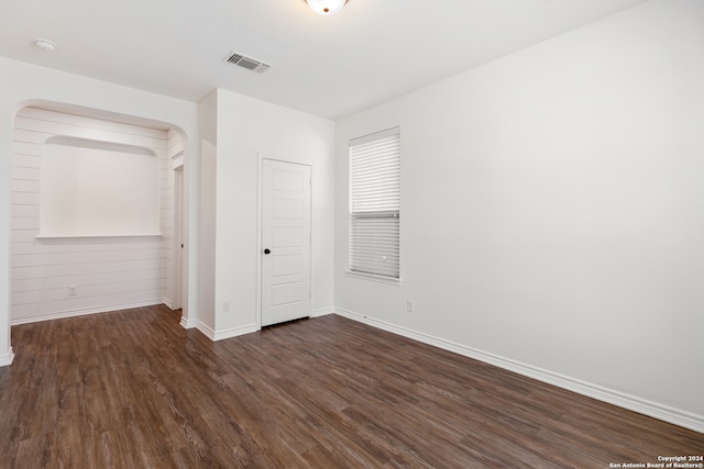 unfurnished bedroom with a closet and dark hardwood / wood-style flooring