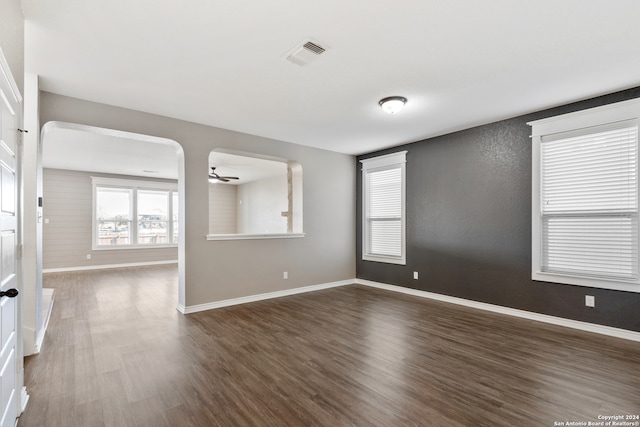 unfurnished room with ceiling fan and dark wood-type flooring