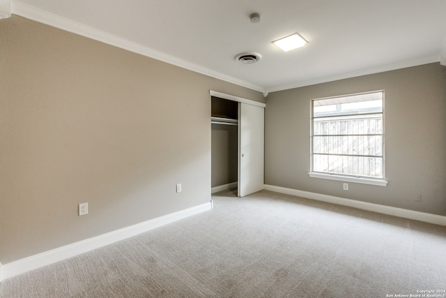 unfurnished bedroom with light carpet, a closet, and ornamental molding