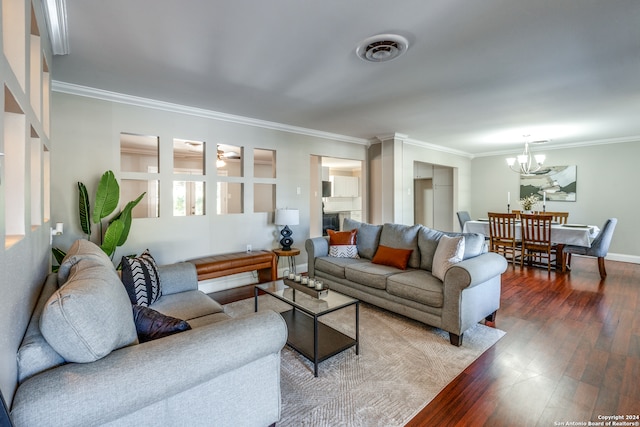 living room with hardwood / wood-style floors, ornamental molding, and a chandelier