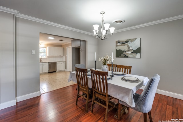 dining space featuring a chandelier, light hardwood / wood-style flooring, crown molding, and sink