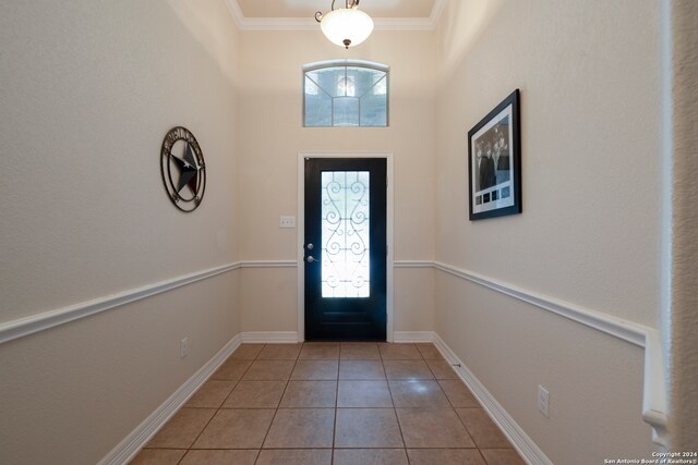 foyer with plenty of natural light, light tile patterned floors, and ornamental molding