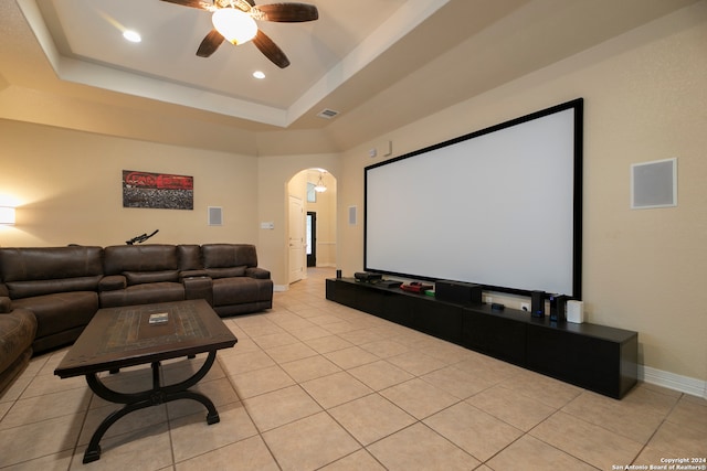 tiled cinema room with a raised ceiling and ceiling fan