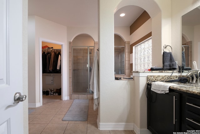 bathroom featuring tile patterned flooring, vanity, and a shower with door