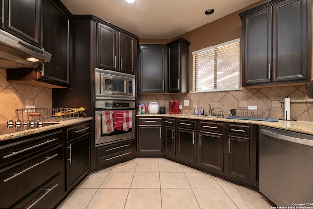 kitchen featuring ventilation hood, backsplash, light tile patterned floors, and stainless steel appliances