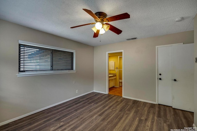 unfurnished bedroom with ceiling fan, a closet, dark wood-type flooring, and a textured ceiling