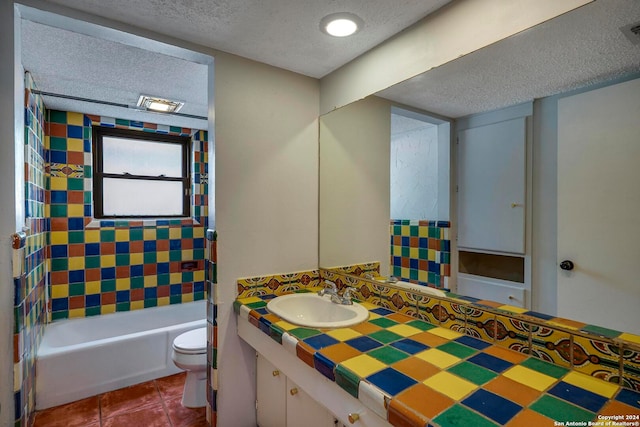 full bathroom featuring tile patterned floors, a textured ceiling, toilet, shower / washtub combination, and vanity