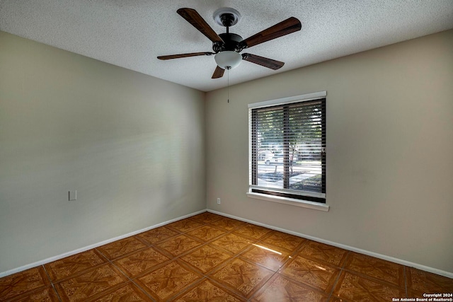 spare room with a textured ceiling and ceiling fan