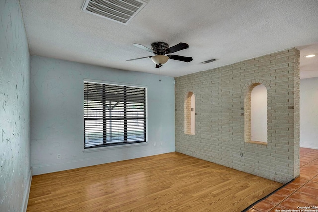 unfurnished room with ceiling fan, light hardwood / wood-style floors, and a textured ceiling