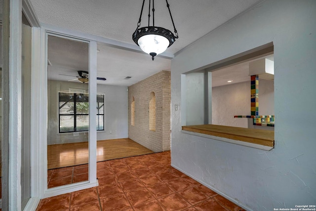 entrance foyer featuring ceiling fan, wood-type flooring, and a textured ceiling