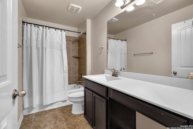 full bathroom featuring shower / bath combo with shower curtain, vanity, a textured ceiling, and toilet