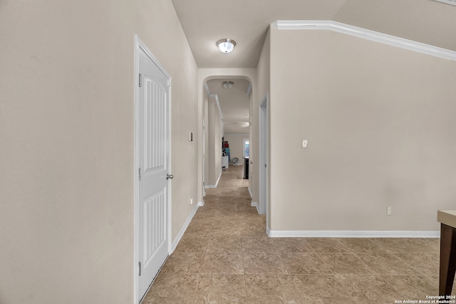 hallway featuring ornamental molding and vaulted ceiling