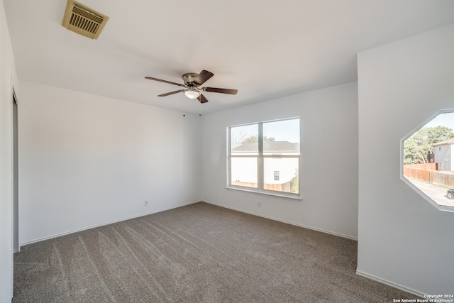 carpeted spare room with ceiling fan