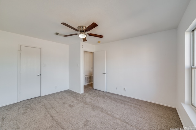 unfurnished bedroom with light colored carpet and ceiling fan