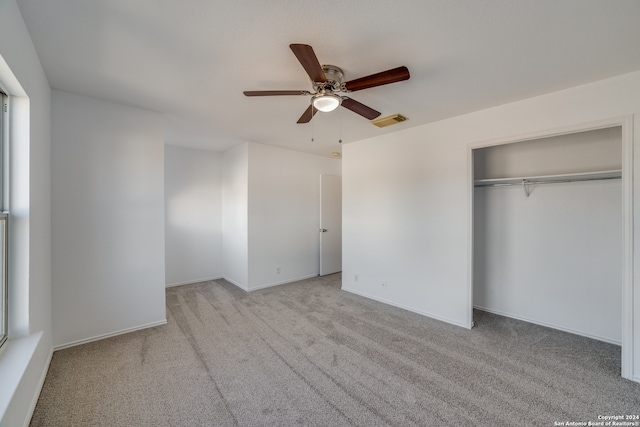 unfurnished bedroom featuring ceiling fan, light carpet, and a closet