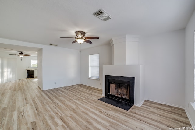 unfurnished living room with ceiling fan and light hardwood / wood-style floors