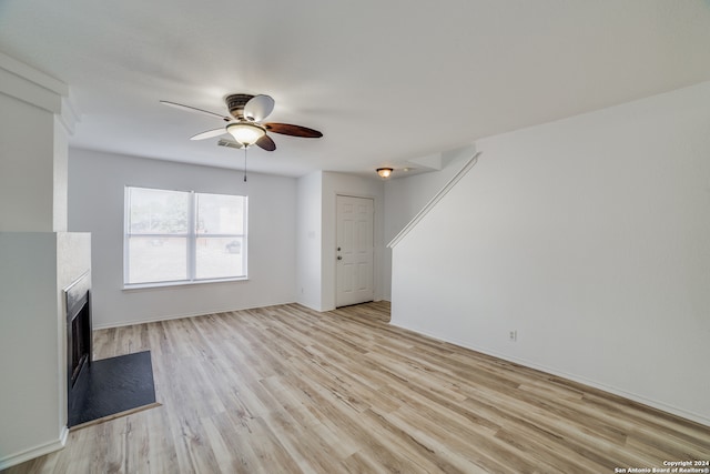 unfurnished living room with light wood-type flooring and ceiling fan