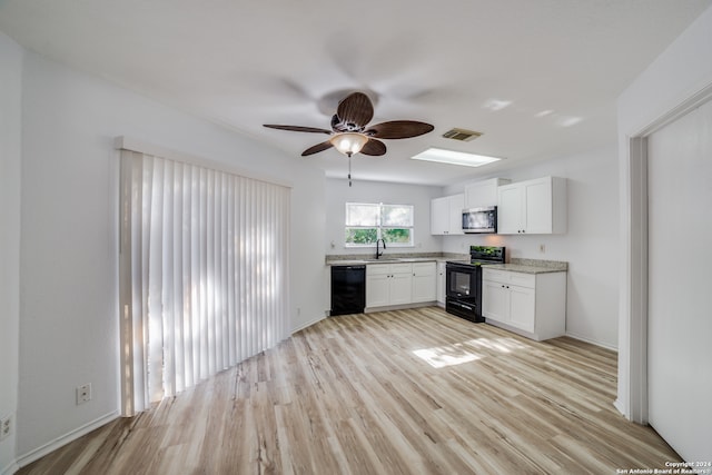 kitchen with sink, light hardwood / wood-style floors, white cabinetry, and black appliances