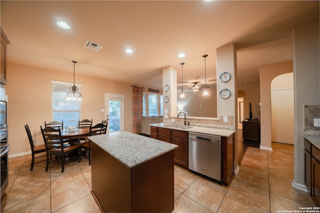 kitchen featuring light stone countertops, appliances with stainless steel finishes, ceiling fan, sink, and pendant lighting