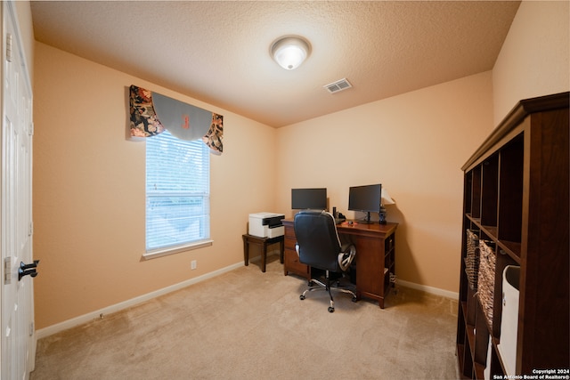 carpeted office space featuring a textured ceiling