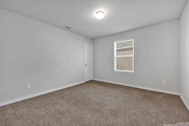 carpeted spare room with a textured ceiling