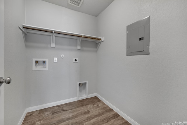 washroom featuring washer hookup, electric dryer hookup, wood-type flooring, electric panel, and hookup for a gas dryer