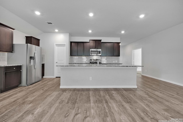 8559 Laxey Wheel, San Antonio, TX 78254 - kitchen with appliances with stainless steel finishes, tasteful backsplash, a center island with sink, dark brown cabinetry, and recessed lighting