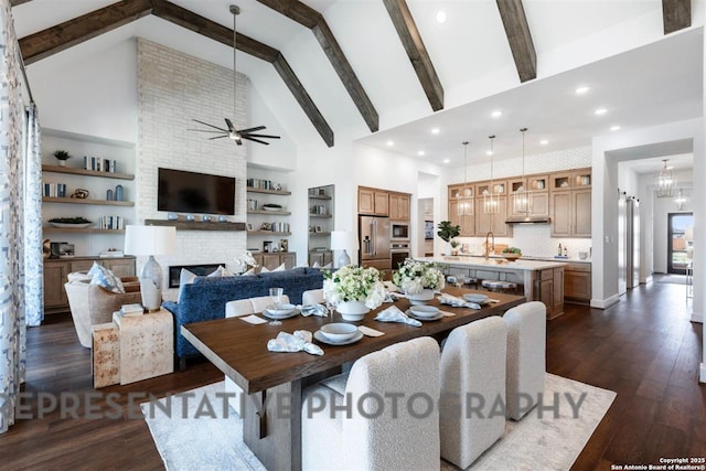 11714 Warlock, San Antonio, TX 78254 - dining space with dark wood-style floors, beam ceiling, a large fireplace, high vaulted ceiling, and ceiling fan with notable chandelier