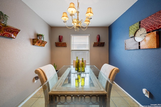 tiled dining room with a chandelier