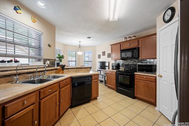 kitchen featuring decorative backsplash, sink, black appliances, light tile patterned floors, and decorative light fixtures