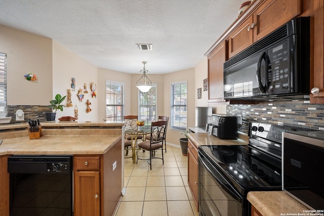 kitchen featuring backsplash, a textured ceiling, black appliances, light tile patterned floors, and hanging light fixtures