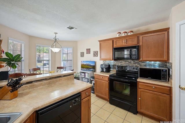 kitchen featuring decorative backsplash, a textured ceiling, black appliances, light tile patterned floors, and hanging light fixtures