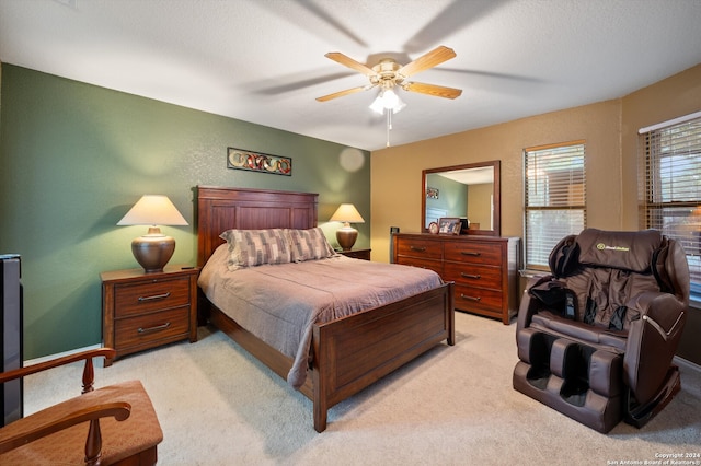 carpeted bedroom featuring ceiling fan and a textured ceiling